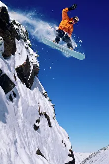 Man on a snowboard jumping off a cornice at Snowbird Resort in Little Cottonwood Man on a snowboard jumping off a cornice at Snowbird Resort in Little Cottonwood