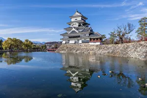 The Matsumoto Castle with reflection in the moat with bridge The Matsumoto Castle with reflection in the moat with bridge