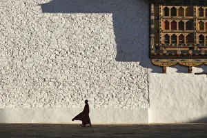 Monk walks through the courtyard of Rinpung Dzong (Monastery) also called Paro Dzong Monk walks through the courtyard of Rinpung Dzong (Monastery) also called Paro Dzong