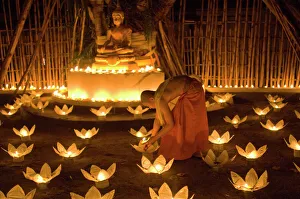 Monks lighting khom loy candles and lanterns for Loi Krathong festival Monks lighting khom loy candles and lanterns for Loi Krathong festival