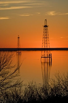 Oil well derricks in Lake Arrowhead near Wichita Falls, Texas, USA at sunset, winter Oil well derricks in Lake Arrowhead near Wichita Falls, Texas, USA at sunset, winter