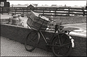 An old fashioned bike with basket leaning again brick wall on an old farm An old fashioned bike with basket leaning again brick wall on an old farm