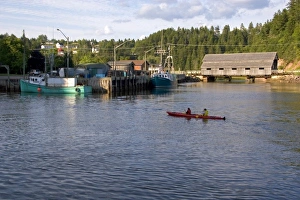 People sea kayaking at high tide in the Bay of Fundy at St. Martins, New Brunswick, Canada People sea kayaking at high tide in the Bay of Fundy at St. Martins, New Brunswick, Canada