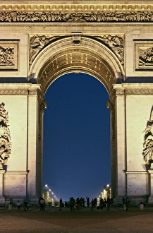 People standing under the Arc de Triomphe at night, Paris, France People standing under the Arc de Triomphe at night, Paris, France