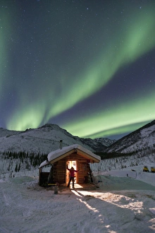 A person stands in the doorway of the Caribou Bluff cabin and watches in awe as the A person stands in the doorway of the Caribou Bluff cabin and watches in awe as the