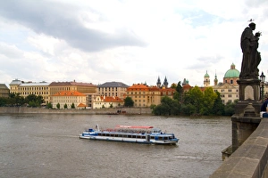 River boat on Vitava River and the famous Charles Bridge of tourist city of Prague River boat on Vitava River and the famous Charles Bridge of tourist city of Prague