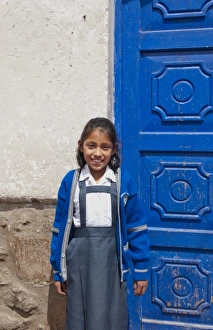 School child aged 10 in uniform and blue door in small town of Pisaq Peru (MR) School child aged 10 in uniform and blue door in small town of Pisaq Peru (MR)