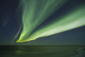 Shimmering curtains of green Aurora borealis dance in the southern sky over a lagoon Shimmering curtains of green Aurora borealis dance in the southern sky over a lagoon