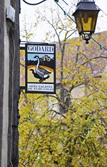 Sign advertising Godard Foie Gras, Duck or Goose fat liver. Tree and lantern in background Sign advertising Godard Foie Gras, Duck or Goose fat liver. Tree and lantern in background