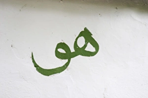 Sign painted on the white wall meaning Him (God) in Arab writing Sign painted on the white wall meaning Him (God) in Arab writing