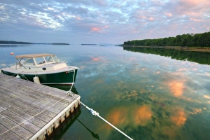 Small pleasure boat at dock while sunset clouds reflect in Sullivan Bay near Hancock Small pleasure boat at dock while sunset clouds reflect in Sullivan Bay near Hancock