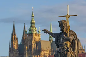 Statue of St. John the Baptist on the Charles Bridge with the Prague Castle and St Statue of St. John the Baptist on the Charles Bridge with the Prague Castle and St