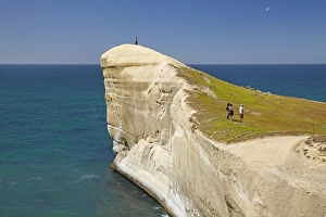 Tourists on cliff top at Tunnel Beach, Dunedin, South Island, New Zealand Tourists on cliff top at Tunnel Beach, Dunedin, South Island, New Zealand
