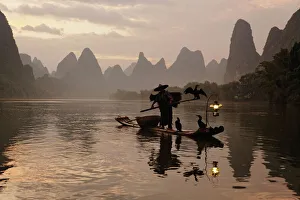 Traditional Chinese fisherman with cormorants on Li River at sunrise, near Guilin, China Traditional Chinese fisherman with cormorants on Li River at sunrise, near Guilin, China