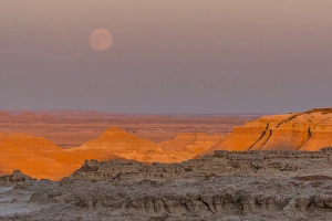 USA, South Dakota, Badlands National Park. Moonrise over rugged landscape at sunset USA, South Dakota, Badlands National Park. Moonrise over rugged landscape at sunset