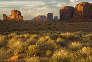 USA, Utah, Monument Valley National Park. Sunrise illumines rock formations and grass on butte USA, Utah, Monument Valley National Park. Sunrise illumines rock formations and grass on butte