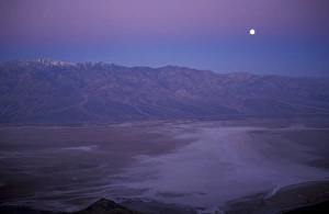 View of snow on Telescope Peak in Death Valley at sunrise with full moon descending View of snow on Telescope Peak in Death Valley at sunrise with full moon descending