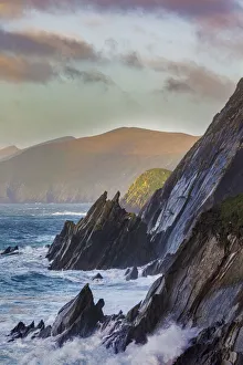 Waves crash into cliffs on Dunmore Head with Blasket Islands on the Dingle Peninsula Waves crash into cliffs on Dunmore Head with Blasket Islands on the Dingle Peninsula