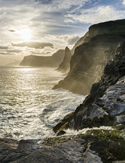 The west coast near Traelanipa with waterfall Bosdalafossur at sunset. The island Vagar The west coast near Traelanipa with waterfall Bosdalafossur at sunset. The island Vagar