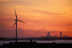 Wind Turbine in Hull, Massachusetts. The Boston skyline is in the distance. Sunset Wind Turbine in Hull, Massachusetts. The Boston skyline is in the distance. Sunset