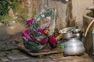 Woman washing dishes. Fatehpur Sikri village. Bharatpur. Rajasthan. India Woman washing dishes. Fatehpur Sikri village. Bharatpur. Rajasthan. India