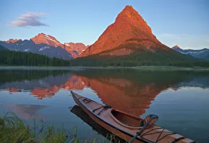Wooden kayak in Swiftcurrent Lake at sunrise in the Many Glacier Valley of Glacier Wooden kayak in Swiftcurrent Lake at sunrise in the Many Glacier Valley of Glacier