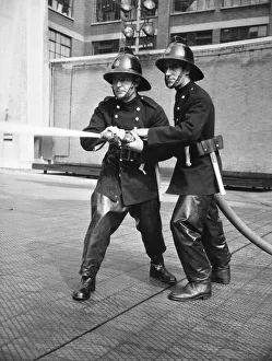 Firefighters taking part in a hose training drill Firefighters taking part in a hose training drill