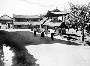 CHINA: CHEFANG, c1940. A street scene in Chefang, China, with three women carrying baskets CHINA: CHEFANG, c1940. A street scene in Chefang, China, with three women carrying baskets