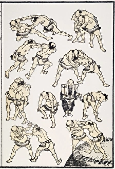 Japanese Sumo wrestlers practicing for a match. At center, with a fan, is the referee Japanese Sumo wrestlers practicing for a match. At center, with a fan, is the referee
