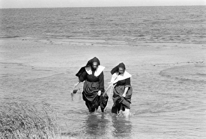 LONG ISLAND: CLAMMING, 1957. Two nuns in habits, clam digging in the water off of Long Island LONG ISLAND: CLAMMING, 1957. Two nuns in habits, clam digging in the water off of Long Island