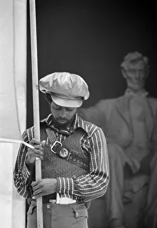 A man holding a banner on the steps of the Lincoln Memorial while attending a Black A man holding a banner on the steps of the Lincoln Memorial while attending a Black