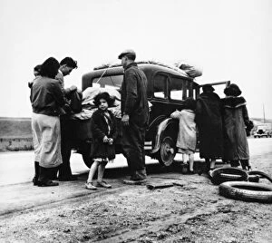 MEXICAN MIGRANTS, 1936. A Mexican family of migrant workers with a flat tire along