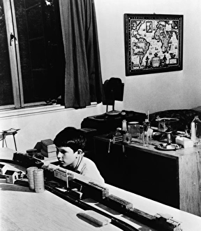 Vintage Bedroom Decor Prints: MODEL TRAIN, c1944. A boy plays with a model train set in his bedroom, Greenbelt, Maryland