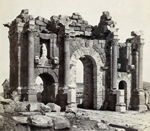 TIMGAD: ARCH OF TRAJAN. The Triumphal Arch of Trajan at Timgad, Algeria. Photograph TIMGAD: ARCH OF TRAJAN. The Triumphal Arch of Trajan at Timgad, Algeria. Photograph