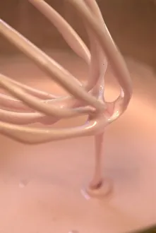 Beating syrup into egg whites to create marshmallow sweets Beating syrup into egg whites to create marshmallow sweets