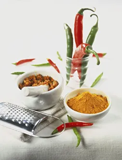 Curcuma longa, ground Turmeric in small ceramic bowl, ground spices in pestle and mortar Curcuma longa, ground Turmeric in small ceramic bowl, ground spices in pestle and mortar