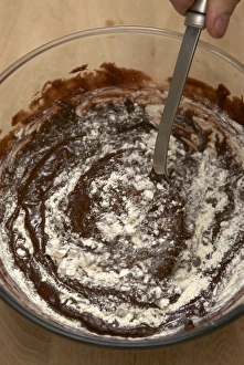 Folding in the flour to a chocolate mixture Folding in the flour to a chocolate mixture