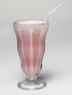 glass of strawberry milkshake with straw
