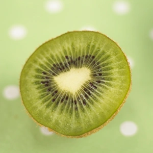 Half cut kiwi fruit on green polka dot tablecloth Half cut kiwi fruit on green polka dot tablecloth
