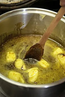 Heating a mixture of syrup, treacle, butter and sugar Heating a mixture of syrup, treacle, butter and sugar