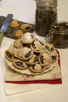 Mince pies piled onto a plate and sprinkled in icing sugar Mince pies piled onto a plate and sprinkled in icing sugar