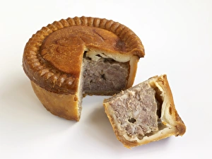 Pork pie with pastry crust, and slice showing meat inside, close-up Pork pie with pastry crust, and slice showing meat inside, close-up