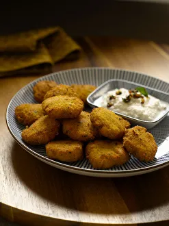 Spicy lentils fritters with coconut chutney, close-up Spicy lentils fritters with coconut chutney, close-up