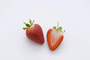 One strawberry and half strawberry, close-up One strawberry and half strawberry, close-up