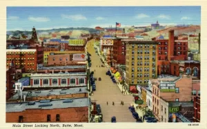 Prints of Birds-eye view of Main Street looking north. Traffic and pedestrians can be seen on the street below. Rolling hills are in the background Vintage Postcard Prints: Main Street Looking North Print, Birds-eye View of Butte Montana