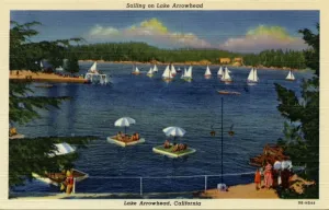 Prints of View shows sailboats on Lake Arrowhead. People on floating platforms are in the forefront. A group of people look out at the lake from the shoreline Vintage Postcard Prints: Lake Arrowhead Sailboats Print