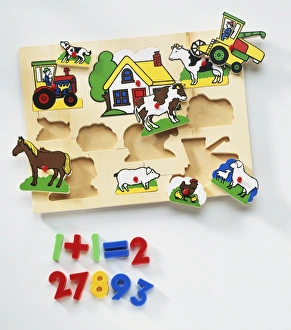 Wooden board with holes fitting shapes of farm animals, house and tractor, numbers from one to ten underneath Wooden board with holes fitting shapes of farm animals, house and tractor, numbers from one to ten underneath