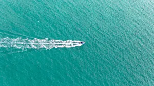 Aerial view of fast travelling boat on an island Aerial view of fast travelling boat on an island