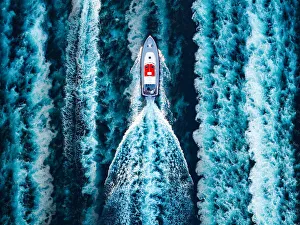 Aerial view of a motorboat surrounded by boat water wakes Aerial view of a motorboat surrounded by boat water wakes