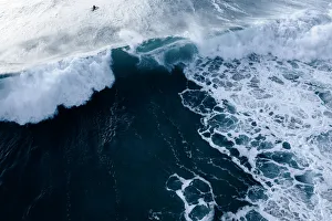Aerial Viewpoint of a bright sunrise and deep blue ocean waters with people surfing Aerial Viewpoint of a bright sunrise and deep blue ocean waters with people surfing